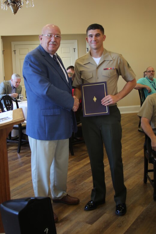 Cpl. Jared Hall (right) receives the Military Family of the Quarter Award from George Liner, Craven County Commissioner during a reception at the New Bern Country Club in New Bern, N.C., Sept. 8. The family received awards, gifts, gift certificates and publicity from the Havelock Military Affairs Committee and the New Bern Military Alliance Committee in appreciation for their service. Hall is an aviation communications technician with Marine Air Support Squadron 1. (U.S. Marine Corps photo by Lance Cpl. Mackenzie Gibson/Released)