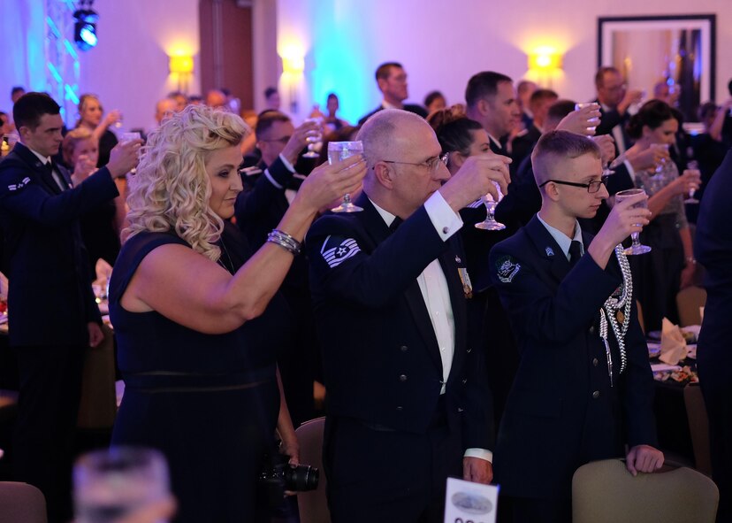 Team McConnell members raise water glasses to toast Prisoners of War and those Missing In Action during the Air Force Ball Sept. 10, 2016, Wichita, Kans. At each Air Force Ball, a symbolic table is set to remind Airmen of the service members who never returned home. (U.S. Air Force photo by Senior Airman Preston Webb)