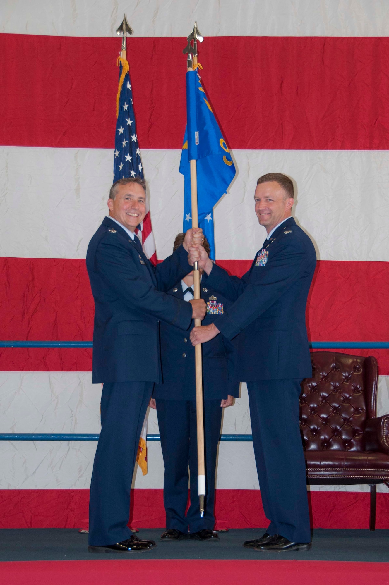 Col. John Breazeale, 301st Fighter Wing commander, smiles as he hands the 301st Operations Group's guidon to its new commander, Col. Stephen Nelson, during a change of command ceremony Sept. 10 at Naval Air Station Fort Worth Joint Reserve Base, Texas. 