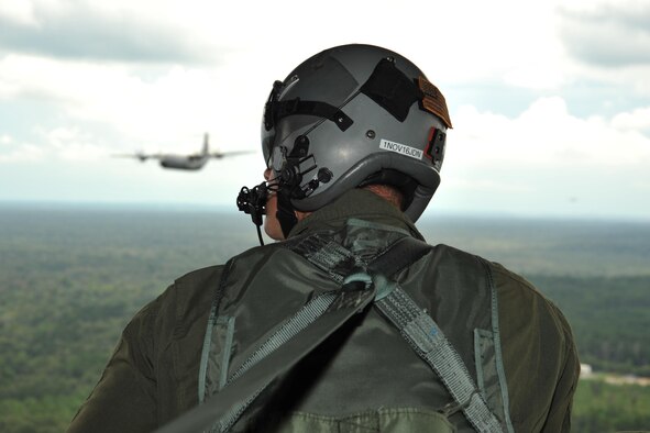 Master Sgt. Chris Sentilles, 815th Airlift Squadron loadmaster, looks out the back of one of the squadrons C-130J cargo aircraft during a four-aircraft training mission Sept. 11, 2016, over the Mississippi Gulfcoast. The aircraft took off from Keesler Air Force Base, Mississippi, and airdropped simulated cargo and heavy equipment over Stennis International Airport, Mississippi. (U.S. Air Force photo/Tech. Sgt. Ryan Labadens)