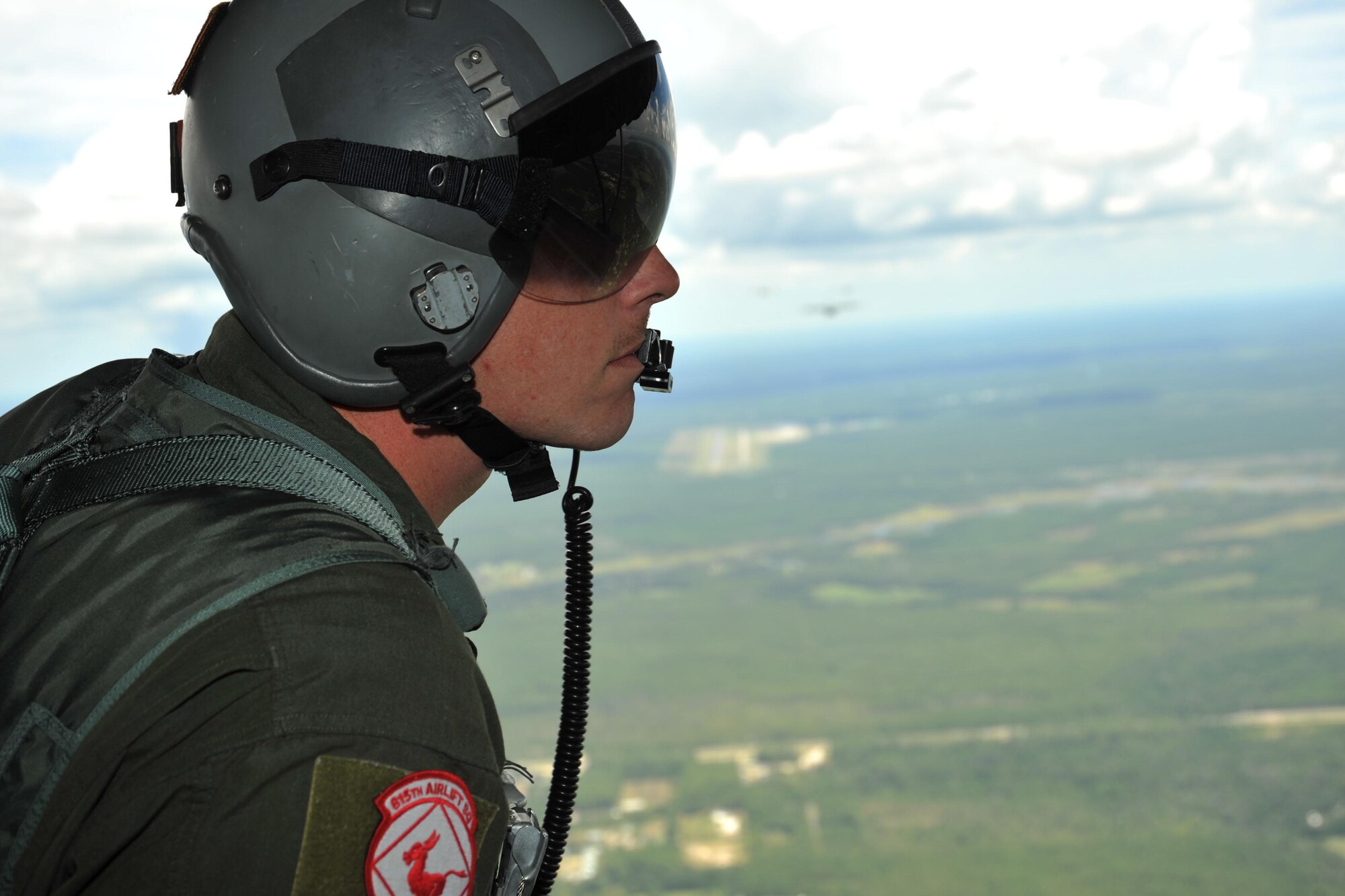 Master Sgt. Chris Sentilles, 815th Airlift Squadron loadmaster, looks out the back of one of the squadrons C-130J cargo aircraft during a four-aircraft training mission Sept. 11, 2016, over the Mississippi Gulfcoast. The aircraft took off from Keesler Air Force Base, Mississippi, and airdropped simulated cargo and heavy equipment over Stennis International Airport, Mississippi. (U.S. Air Force photo/Tech. Sgt. Ryan Labadens)