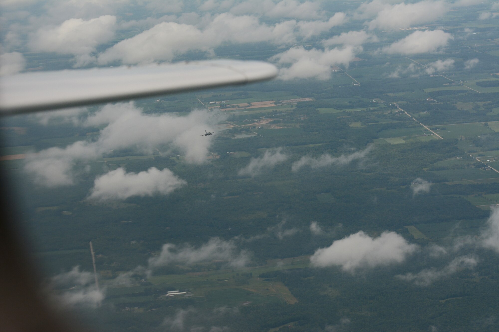 An F-16 Fighting Falcon is spotted through the small window in the back left-side of a Cessna aircraft during a fertile keynote exercise in the airspace above central Wisconsin on July 12, 2016. A fertile keynote is a term used to describe practice intercept missions. The 115th Fighter Wing has been exercising its aerospace control mission since the events of 9/11. (U.S. Air National Guard photo by Staff Sgt. Andrea F. Rhode)