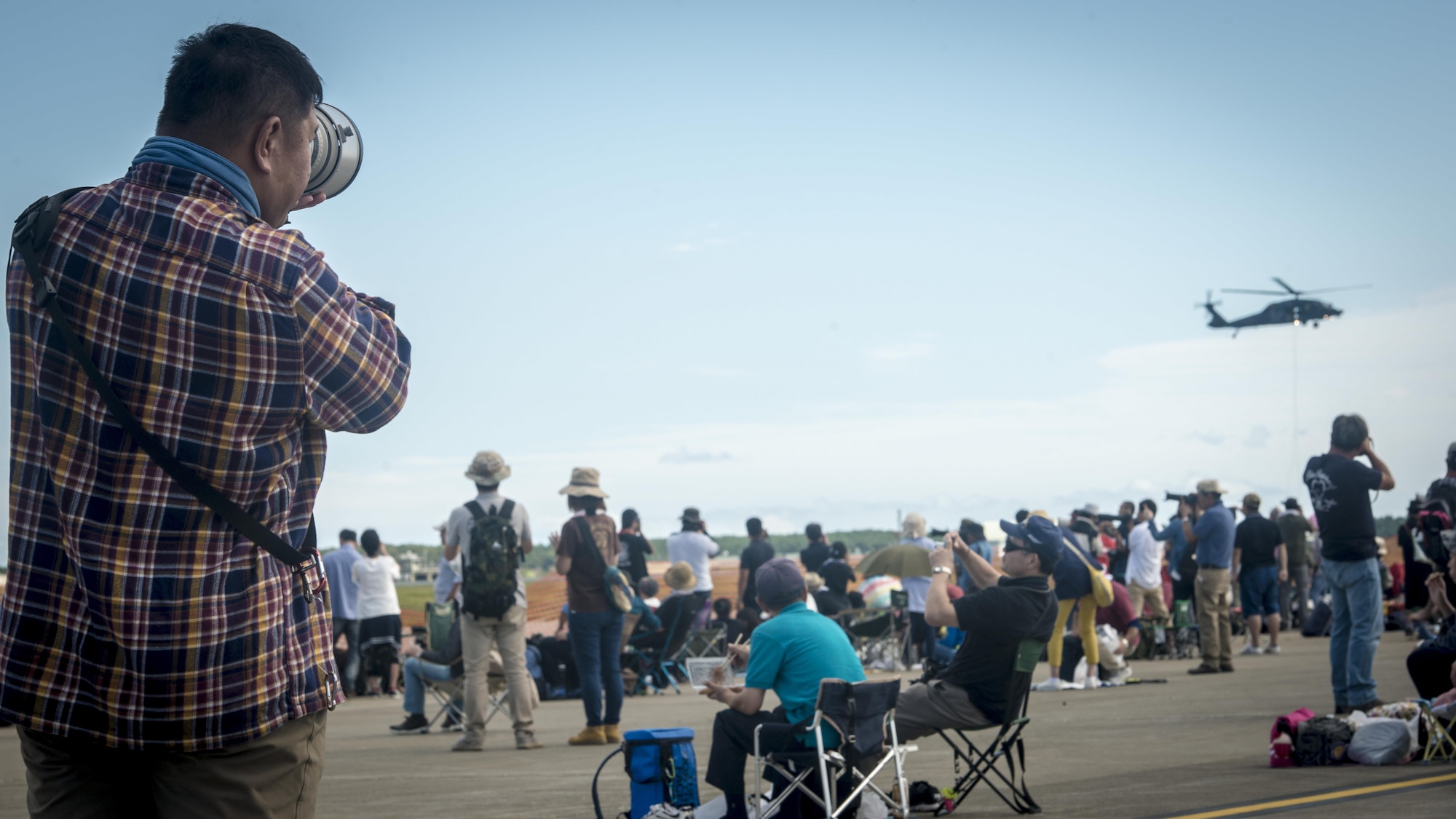 A Japanese man photographs a Japan Air Self-Defense Force UH-60 Black Hawk helicopter during a rescue demonstration during Misawa Air Fest 2016 at Misawa Air Base, Japan, Sept. 11, 2016. The UH-60 serves as a medium life utility transport and air assault aircraft. It is powered by a twin-engine and single four-blade rotor and flown by two pilots and two crew chiefs. The annual air show drew more than 80,000 people from Aomori Prefecture and as far as Akita Prefecture, highlighting the close U.S. and Japan bilateral partnership in the area. (U.S. Air Force photo by Staff Sgt. Benjamin W. Stratton)