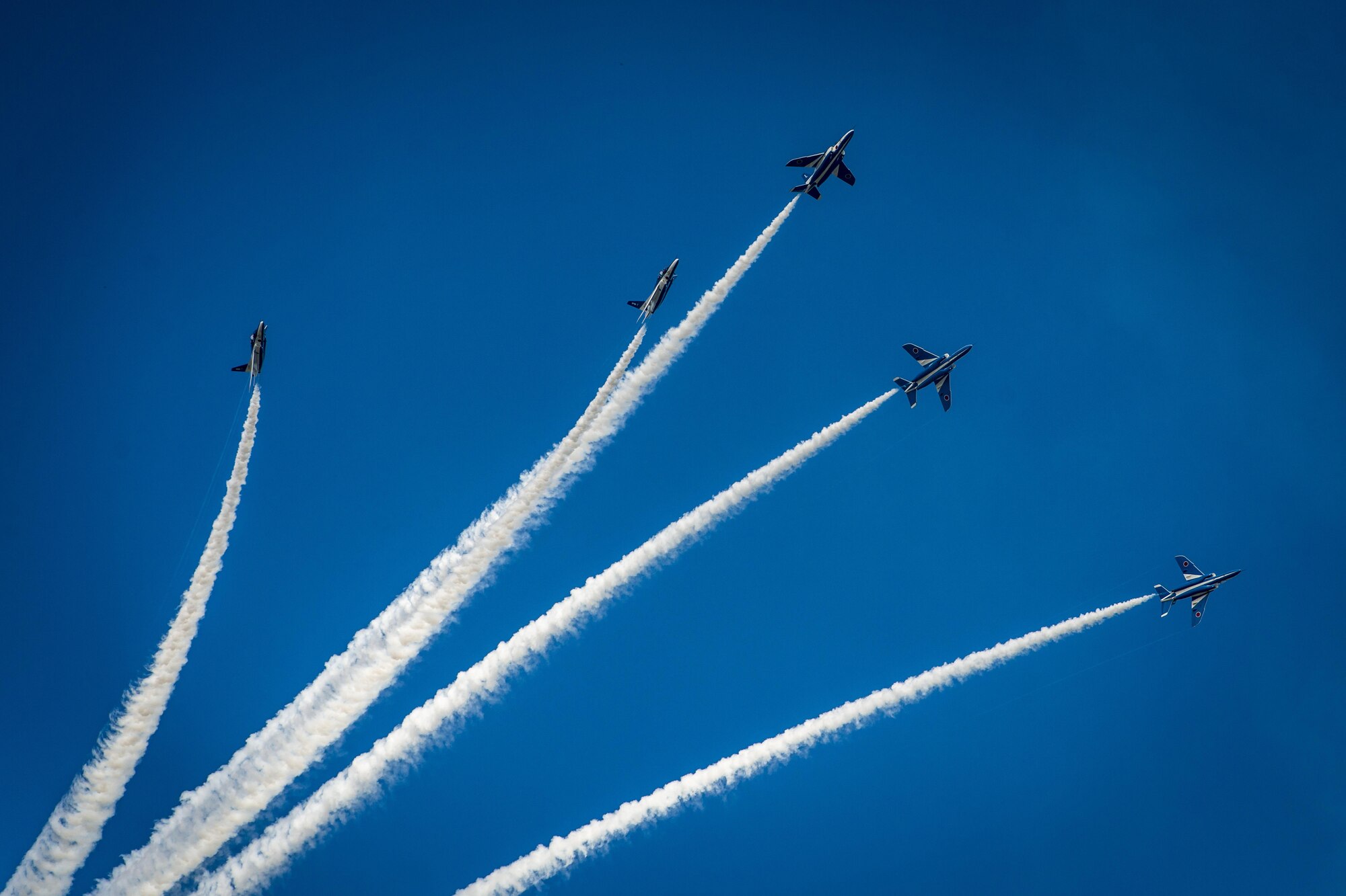 The Japan Air Self-Defense Force Blue Impulse aerial demonstration team performs a split maneuver during Misawa Air Fest 2016 at Misawa Air Base, Japan, Sept. 11, 2016. The Blue Impulse fly the Kawasaki T-4 which is a subsonic intermediate jet trainer aircraft. The T-4 entered service in 1985 and has since been JASDF’s flagship demo team aircraft. The performance lasted through part of the afternoon engaging the more than 80,000 people who attended this annual air show. (U.S. Air Force photo by Staff Sgt. Benjamin W. Stratton)