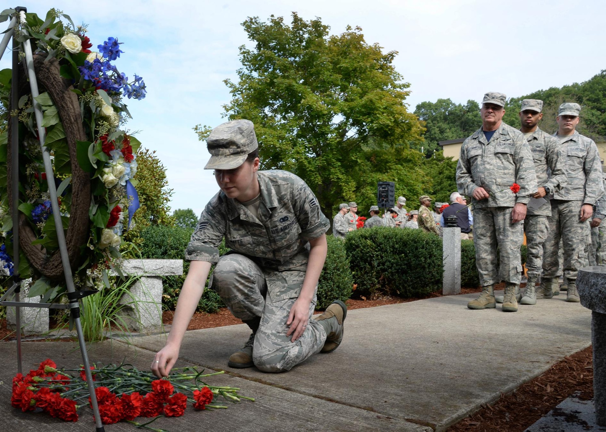 Senior Airman Kara Watts, 66th Air Base Group administration specialist, places a carnation near a wreath following the 15th Anniversary Memorial Remembrance at Hanscom Air Force Base, Mass., Sept. 9. The ceremony was held in remembrance of those who lost their lives on Sept. 11, 2001. (U.S. Air Force photo by Linda LaBonte Britt )