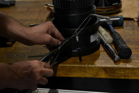 U.S. Air Force Airman Justin Hurd, 20th Component Maintenance Squadron aerospace propulsion apprentice, safety-wires a number one bearing nut installation tool in preparation to attach it to a torque multiplier at Shaw Air Force Base, S.C., Sept. 7, 2016. Fixing the torque multiplier is just one of the many aspects that go into building the engines of the 79 F-16 Fighting Falcons assigned to Shaw. (U.S. Air Force photo by Airman 1st Class Destinee Sweeney)