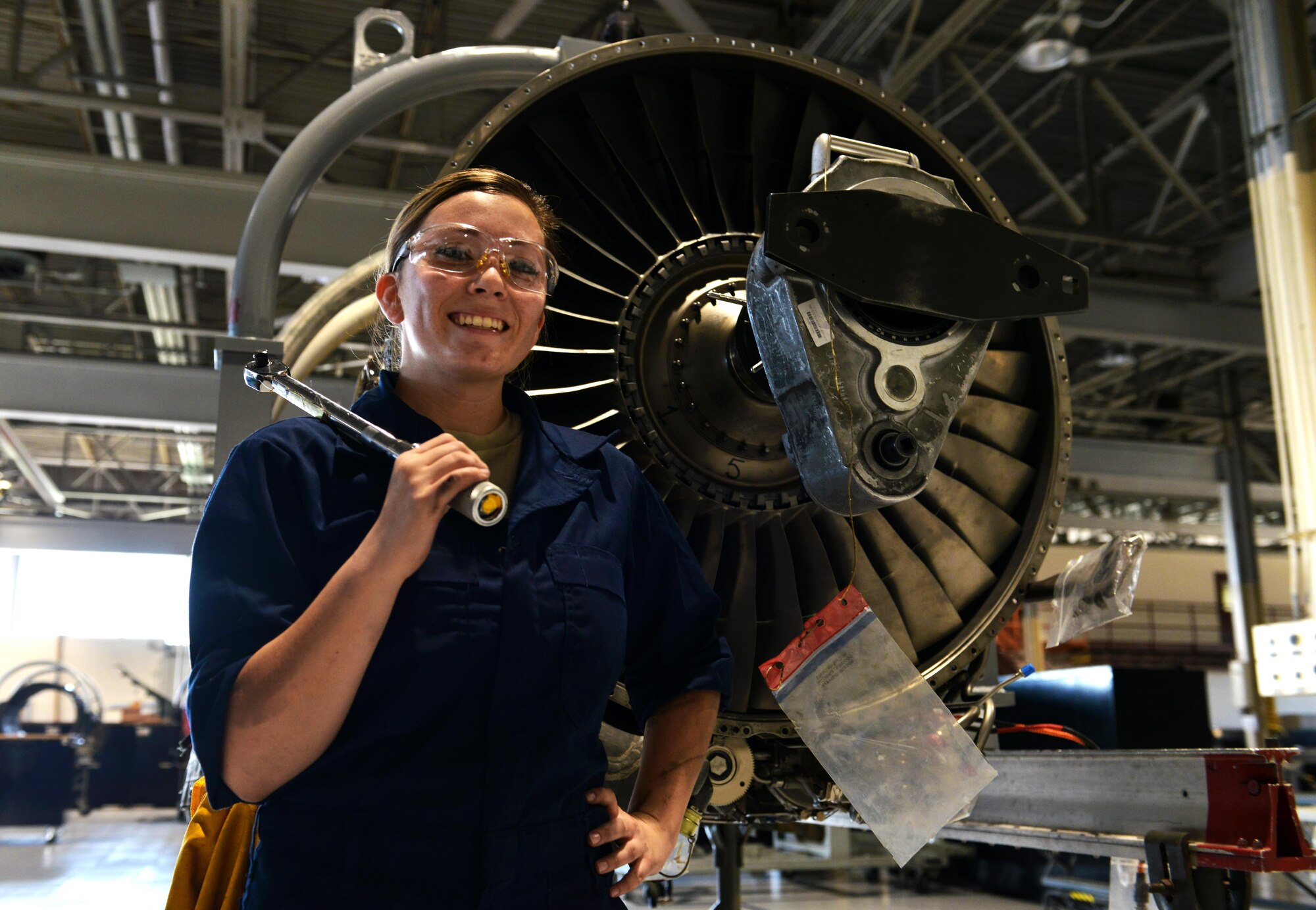 U.S. Air Force Senior Airman Athena Kline, 20th Component Maintenance Squadron aerospace propulsion journeyman, poses for a picture in front of a F-129B engine at Shaw Air Force Base, S.C., Sept. 7, 2016. The aerospace propulsion flight is responsible for rebuilding, repairing and performing preventative maintenance on engines in order to prepare them for flight. (U.S. Air Force photo by Airman 1st Class Destinee Sweeney)
