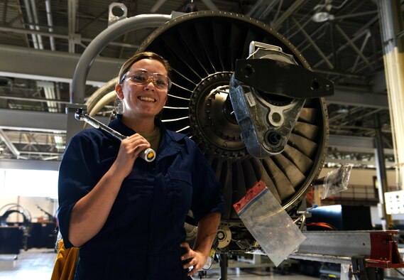 U.S. Air Force Senior Airman Athena Kline, 20th Component Maintenance Squadron aerospace propulsion journeyman, poses for a picture in front of a F-129B engine at Shaw Air Force Base, S.C., Sept. 7, 2016. The aerospace propulsion flight is responsible for rebuilding, repairing and performing preventative maintenance on engines in order to prepare them for flight. (U.S. Air Force photo by Airman 1st Class Destinee Sweeney)