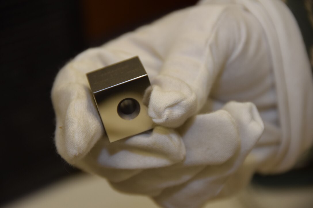 The gloved right hand of Staff Sgt. Jacob Lober, 379th Expeditionary Expeditionary Maintenance Squadron Precision Measurement Equipment Laboratory craftsman, handles a steel gauge block Aug. 24, 2016, Al Udeid Air Base, Qatar. The block could be used to calibrate a micrometer, calipers or anything that have a length calibration. (U.S. Air Force photo/Technical Sgt. CarlosJ. Treviño/Released)