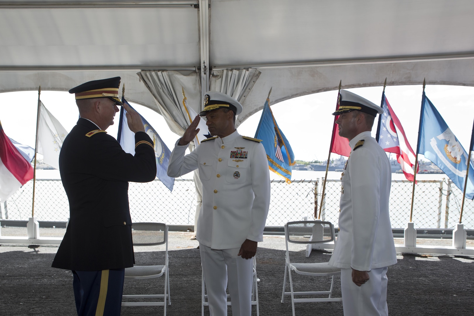 Army Col. Rick Ellis (left) salutes Rear Adm. Vince Griffith (center) as the new DLA Pacific commander, Navy Capt. Timothy Daniels (right), looks on in a Sept. 6 change-of-command ceremony aboard the USS Missouri, Joint Base Pearl Harbor/Hickam, Hawaii.