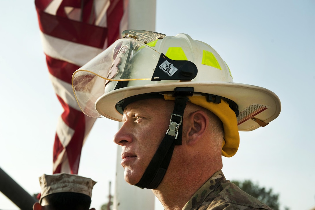 A Defense Department civilian firefighter participates during the lowering of the American flag to half-staff during a 9/11 remembrance ceremony at Bagram Airfield, Afghanistan, Sept. 11, 2016. Air Force photo by Capt. Korey Fratini