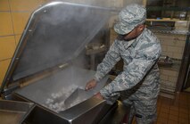 Airman Steven Deleon, 5th Force Support Squadron cook, prepares shrimp at Minot Air Force Base, N.D., Sept. 7, 2016. The upgraded Dakota Inn Dining Facility now offers more food options such as healthier entrée items, a pizza station, a smoothie station and many more fresh options. (U.S. Air Force photo/Airman 1st Class Christian Sullivan