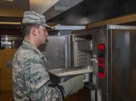 A 5th Force Support Squadron cook, pulls rice from the steamer before lunch at Minot Air Force Base, N.D., Sept. 7, 2016. The new dining facility now offers more food options including a pizza station, an entrée line, and a rotating bar of Mongolian grill, pasta, quesadillas and a sub sandwich bar. (U.S. Air Force photo/Airman 1st Class Christian Sullivan)
