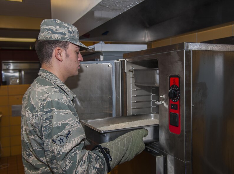 A 5th Force Support Squadron cook, pulls rice from the steamer before lunch at Minot Air Force Base, N.D., Sept. 7, 2016. The new dining facility now offers more food options including a pizza station, an entrée line, and a rotating bar of Mongolian grill, pasta, quesadillas and a sub sandwich bar. (U.S. Air Force photo/Airman 1st Class Christian Sullivan)