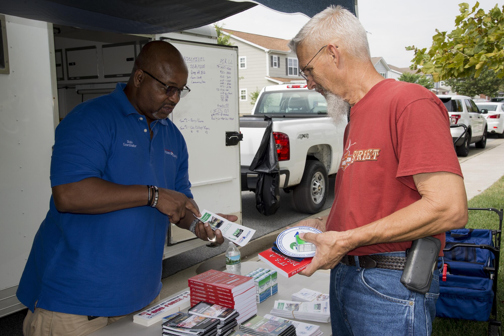 Marny McLee Sr., Delaware Emergency Management Agency education training manager, discusses emergency preparedness with Tom Oliver, father of Staff Sgt. Pat Murphey, 436th Civil Engineer Squadron pavement and construction equipment operator, at the Emergency Management Block Party in base housing on Dover Air Force Base, Del. DEMA representatives travel the state to raise awareness for emergency management. (U.S. Air Force photo by Senior Airman Aaron J. Jenne)