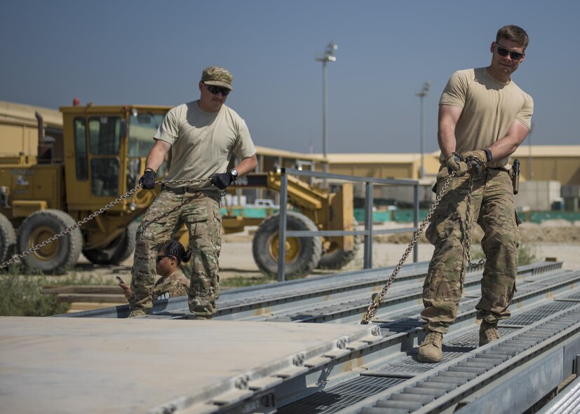 Staff Sgt. Steven Hill (right) and Senior Airman John Gal (left) Central Command Material Recovery Element team members, pull AM-2 Matting onto a high line dock, Bagram Airfield, Afghanistan, Sept. 9, 2016. The CMRE team accounts for and redeploys war reserve assets. The load of matting was packed up and transported to another base for use. (U.S. Air Force photo by Senior Airman Justyn M. Freeman)