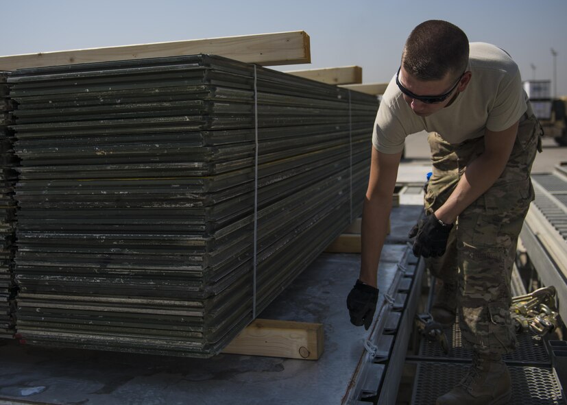 Tech. Sgt. Bradley Stevens, 455th Expeditionary Logistics Squadron Central Command Material Recovery Element team lead, aligns a piece of wood under AM-2 Matting, Bagram Airfield, Afghanistan, Sept. 9, 2016. The CMRE team palletized the matting, which is used to form runways, taxiways, parking and other areas required for aircraft operations and maintenance, and transported it to another base for use. (U.S. Air Force photo by Senior Airman Justyn M. Freeman)