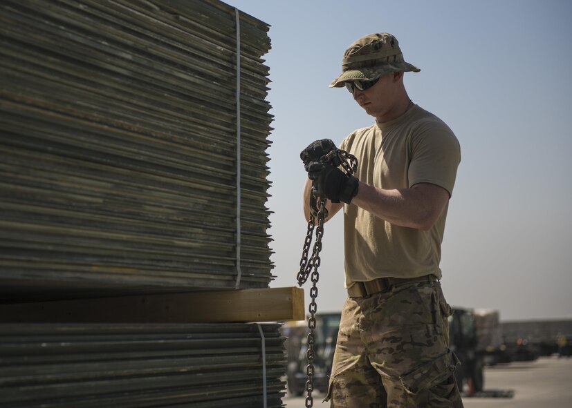 Staff Sgt. Cody Goldade, 455th Expeditionary Logistics Squadron Central Command Material Recovery Element team member, unravels a chain to place around AM-2 Matting, Bagram Airfield, Afghanistan, Sept. 9, 2016. CMRE accounts for and redeploys war reserve assets. The team palletized the matting to be transported to another base for use. (U.S. Air Force photo by Senior Airman Justyn M. Freeman)