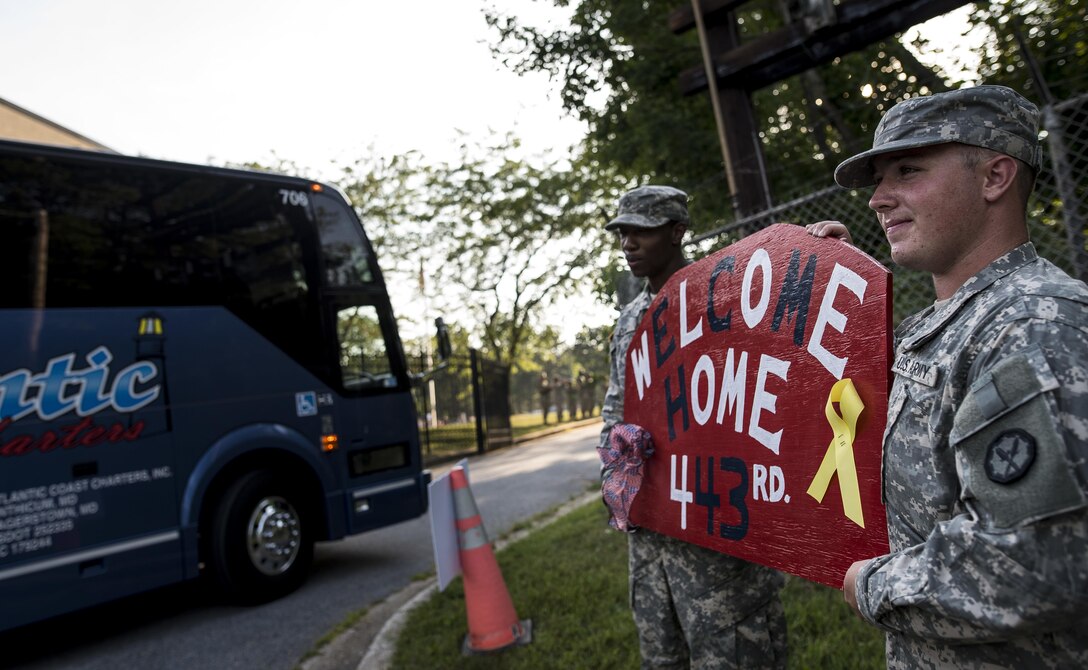 Two U.S. Army Reserve military police Soldiers hold a "Welcome Home" sign for a group of roughly 90 Army Reserve Soldiers from the 443rd Military Police Company, of Owings Mills, Maryland, who returned home after a 10-month deployment to Guantanamo Bay, Cuba, Sept. 9. (U.S. Army Reserve photo by Master Sgt. Michel Sauret)