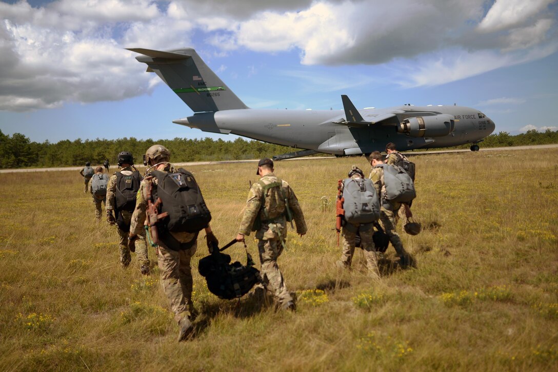 Air Force pararescuemen and combat rescue officers carry their equipment to a C-17 Globemaster before participating in a training jump over Francis S. Gabreski Air National Guard Base in Westhampton Beach, N.Y., Aug. 31, 2016. Air National Guard photo by Staff Sgt. Christopher S. Muncy