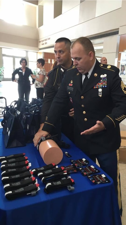 Sgt.1st Class Chris Donaldson, 143d Sustainment Command (Expeditionary) Force Protection Non-Commissioned Officer-in-Charge and Deputy of the Osceola County Sheriff's Office, demonstrates how to apply a pressure tourniquet as part of the Stop The Bleed campaign during a press conference held September 1 at Health First's Holmes Regional Medical Center.