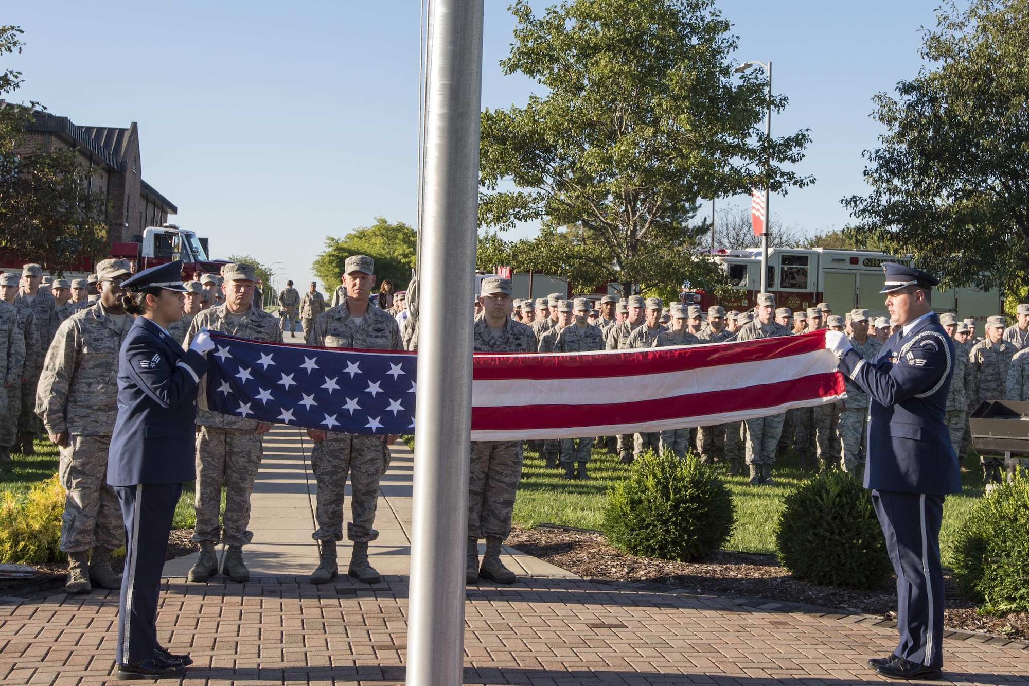 Senior Airman Stephanie Briones, Grissom base honor guard manager, and Senior Airman Ryan Ware, Grissom Base honor guard member, perform a flag folding ceremony during a 9/11 remembrance ceremony at Grissom Air Reserve Base, Ind., Sept. 11, 2016. During the event more than 500 Grissom Airmen, firefighters and civilians joined Americans around the world to share a moment of silence to remember the victims and pay their respects. (U.S. Air Force photo/Tech. Sgt. Benjamin Mota)