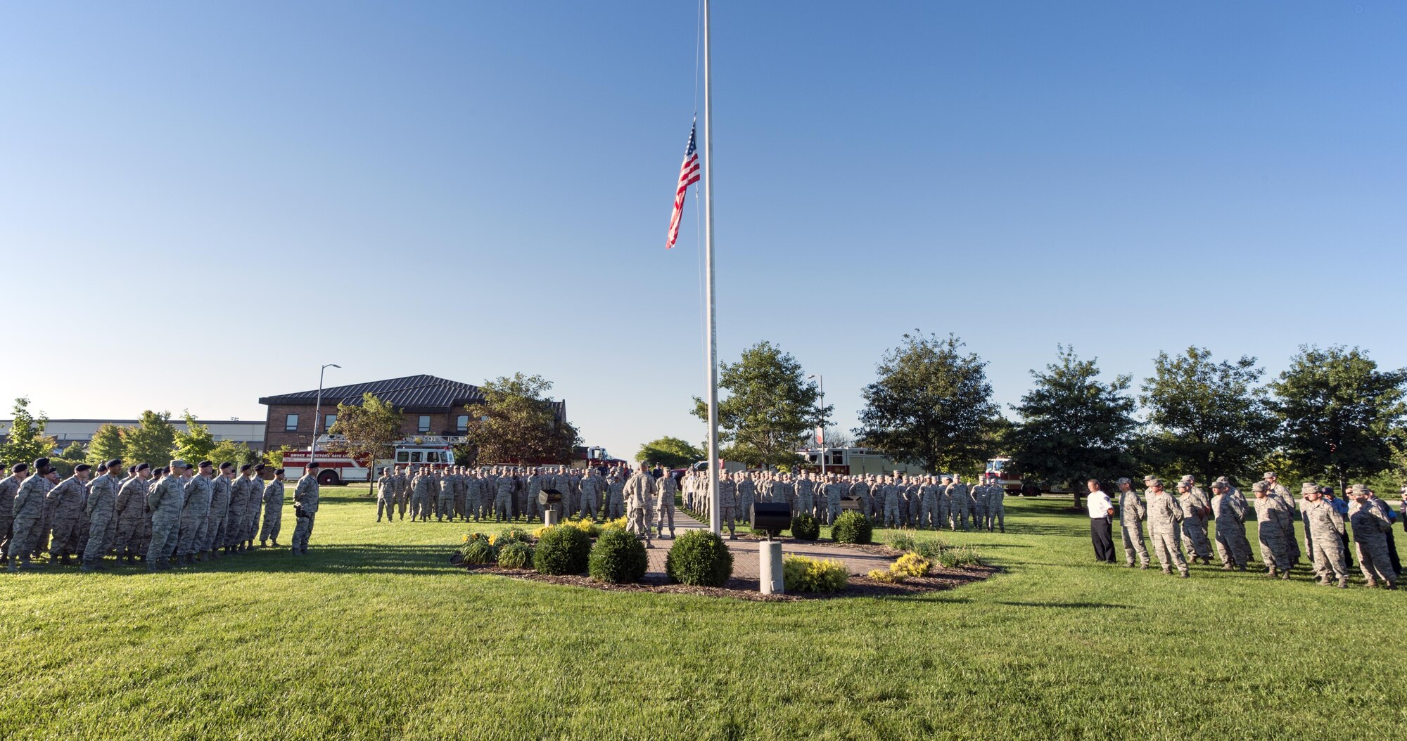 Firefighters, Airmen and civil servants pay respect to an American flag at half-staff during a 9/11 remembrance ceremony at Grissom Air Reserve Base, Ind., Sept. 11, 2016. The base gathered together for the ceremony that began at 8:46 a.m., the same time the first aircraft hit the World Trade Center in 2001. (U.S. Air Force photo/Tech. Sgt. Benjamin Mota)