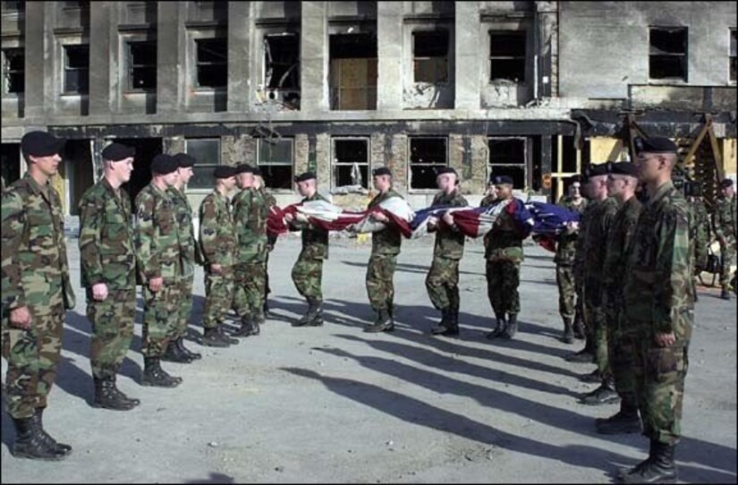 Alpha Company, 3rd Infantry Regiment, “The Old Guard” flag detail folds the U.S. Garrison Flag that has been hanging over the Pentagon after the 9/11 attack, October 11, 2001. PFC Gregory "Erick" Reed, is the second Soldier in formation on the right facing the flag. Today, the flag’s condition is as it was when it was retired. Never cleaned it is still soot-stained and has a small rip in one area. The flag resides in the care of the Army’s Center of Military History and serves as a revered symbol of American pride, ideals and resolve in the face of adversity. (Courtesy photo)