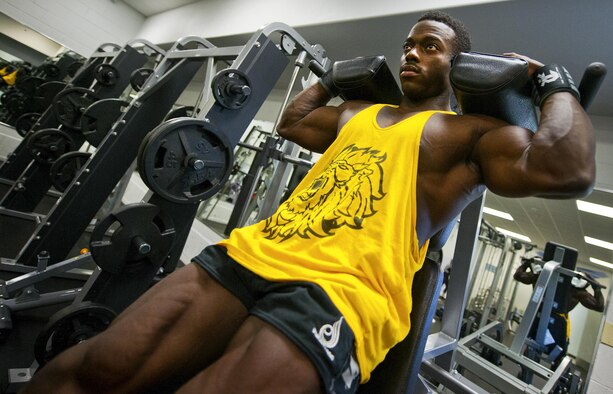 Senior Airman Terrence Ruffin, 16th Electronic Warfare Squadron, performs weighted squats at the fitness center on Eglin Air Force Base, Fla. Ruffin, currently the youngest professional bodybuilder on the circuit at age 22, will compete at the largest bodybuilding competition in the world Sept 17. (U.S. Air Force photo/Samuel King Jr.)