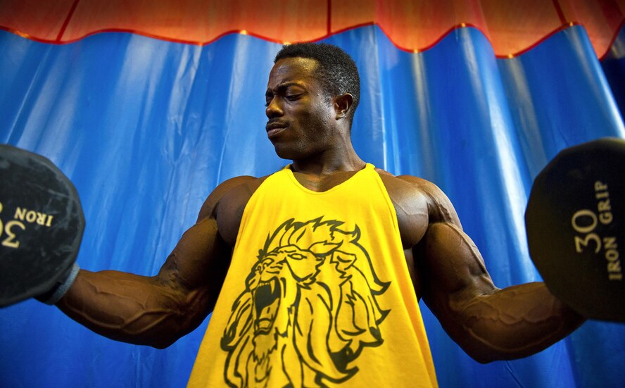 Senior Airman Terrence Ruffin, 16th Electronic Warfare Squadron, flexes while lighting 30-pound dumbbells at the fitness center on Eglin Air Force Base, Fla. Ruffin, currently the youngest professional bodybuilder on the circuit at age 22, will compete at the largest bodybuilding competition in the world Sept 17. (U.S. Air Force photo/Samuel King Jr.)