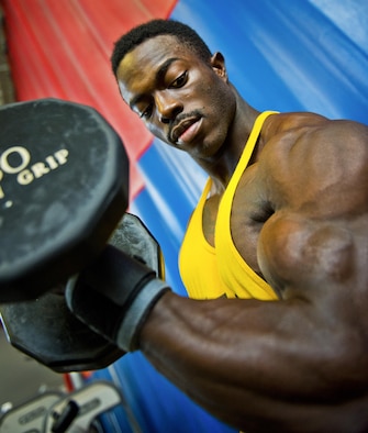 Senior Airman Terrence Ruffin, 16th Electronic Warfare Squadron, curls his arm lifting a 30-pound dumbbell with ease at the fitness center on Eglin Air Force Base, Fla. Ruffin, currently the youngest professional bodybuilder on the circuit at age 22, will compete at the largest bodybuilding competition in the world Sept 17. (U.S. Air Force photo/Samuel King Jr.)