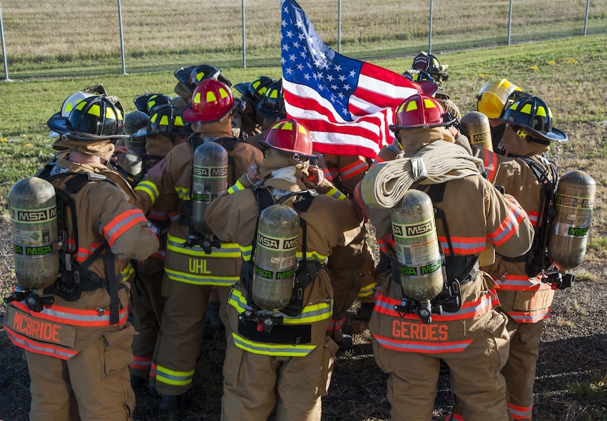 Firemen from the 5th Civil Engineer Squadron huddle up before they start their 9/11 memorial climb at Minot Air Force Base, N.D., Sept. 11, 2016. In honor of the emergency responders who lost their lives in the terrorist attacks of 9/11, the Minot AFB fire department climbed 110 stories, the equivalent of what the twin towers had prior to the attack. (U.S. Air Force photo/Airman 1st Class Christian Sullivan)