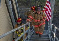 Senior Airman Nickolas Torrez, 5th Civil Engineer Squadron firefighter, leads the way carrying the American flag at Minot Air Force Base, N.D., Sept. 11, 2016. Torrez received this flag during a deployment from an F-16 pilot that carried out anti-terrorism missions. (U.S. Air Force photo/Airman 1st Class Christian Sullivan)