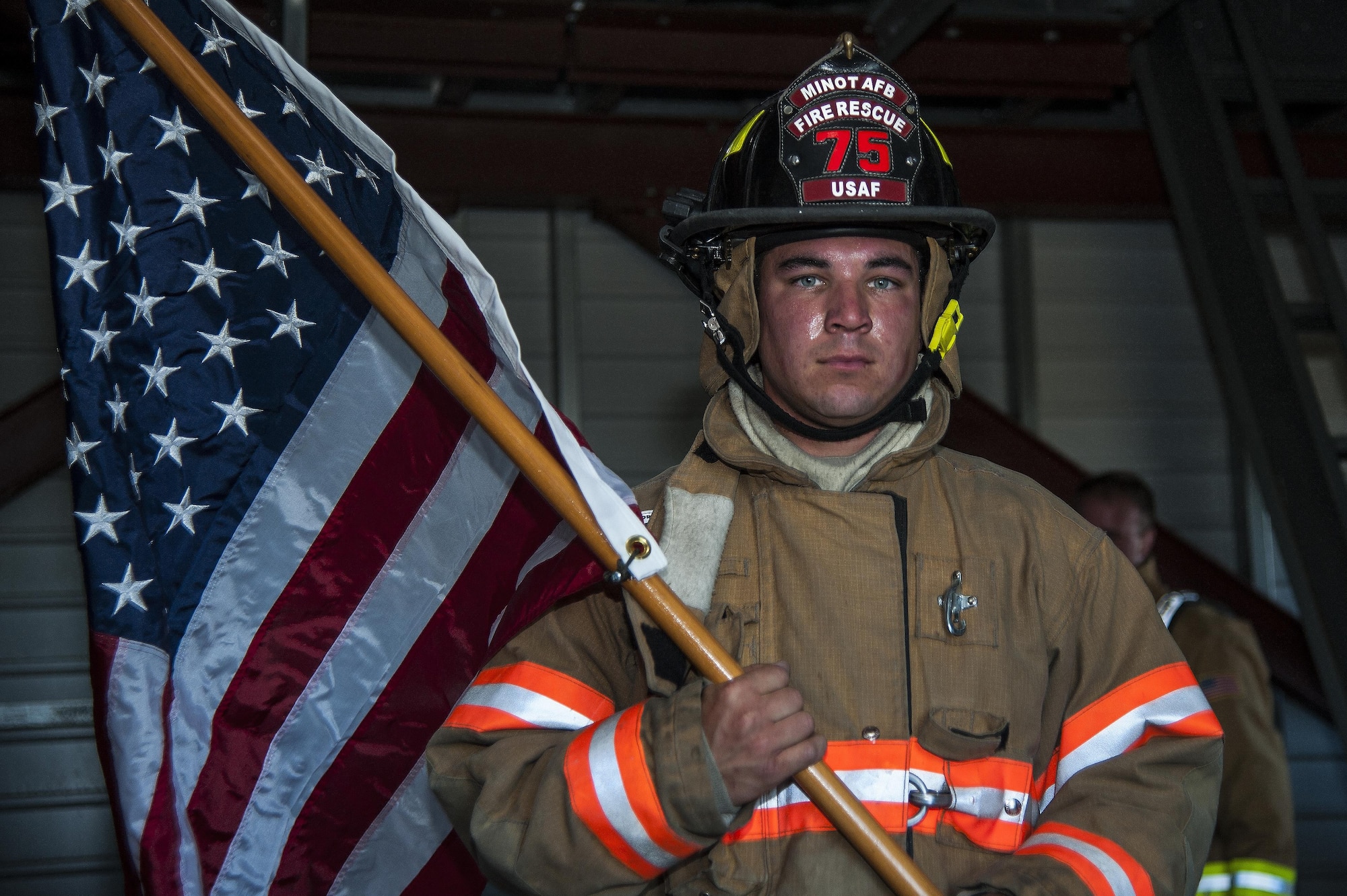 Senior Airman Nickolas Torrez, 5th Civil Engineer Squadron firefighter, leads the way carrying the American flag at Minot Air Force Base, N.D., Sept. 11, 2016. Torrez received this flag while deployed to an undisclosed location from an F-16 pilot that carried out anti-terrorism missions. (U.S. Air Force photo/Airman 1st Class Christian Sullivan)