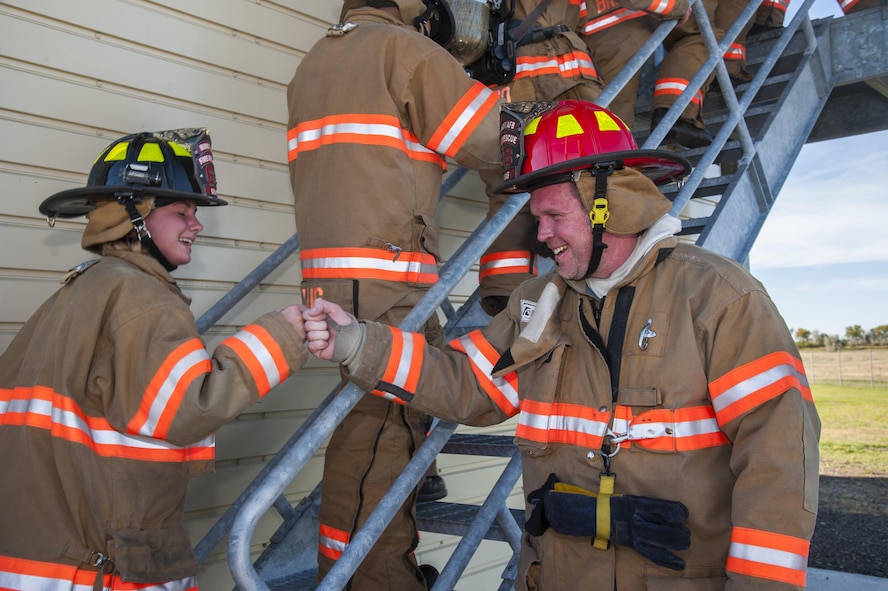 Two Minot firefighters cheer each other on as they climb flights of stairs in honor of 9/11 at Minot Air Force Base, N.D., Sept. 11, 2016. The fire department worked together to climb 110 flights of stairs in honor of the victims of 9/11. (U.S. Air Force photo/Airman 1st Class Christian Sullivan)