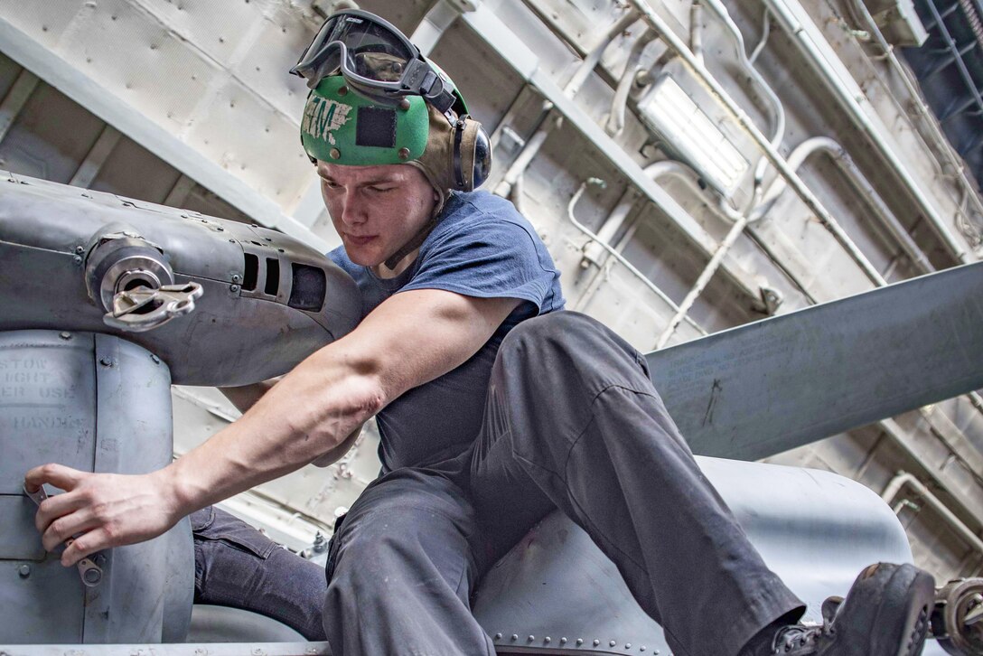Navy Petty Officer 3rd Class Zachary Nalley replaces a panel on an MH-60S Seahawk helicopter in the hangar bay of the aircraft carrier USS Dwight D. Eisenhower in the Persian Gulf, Sept. 8, 2016. The Eisenhower is supporting Operation Inherent Resolve, maritime security operations and theater security cooperation efforts in the U.S. 5th Fleet area of operations. Navy photo by Seaman Joshua Murray