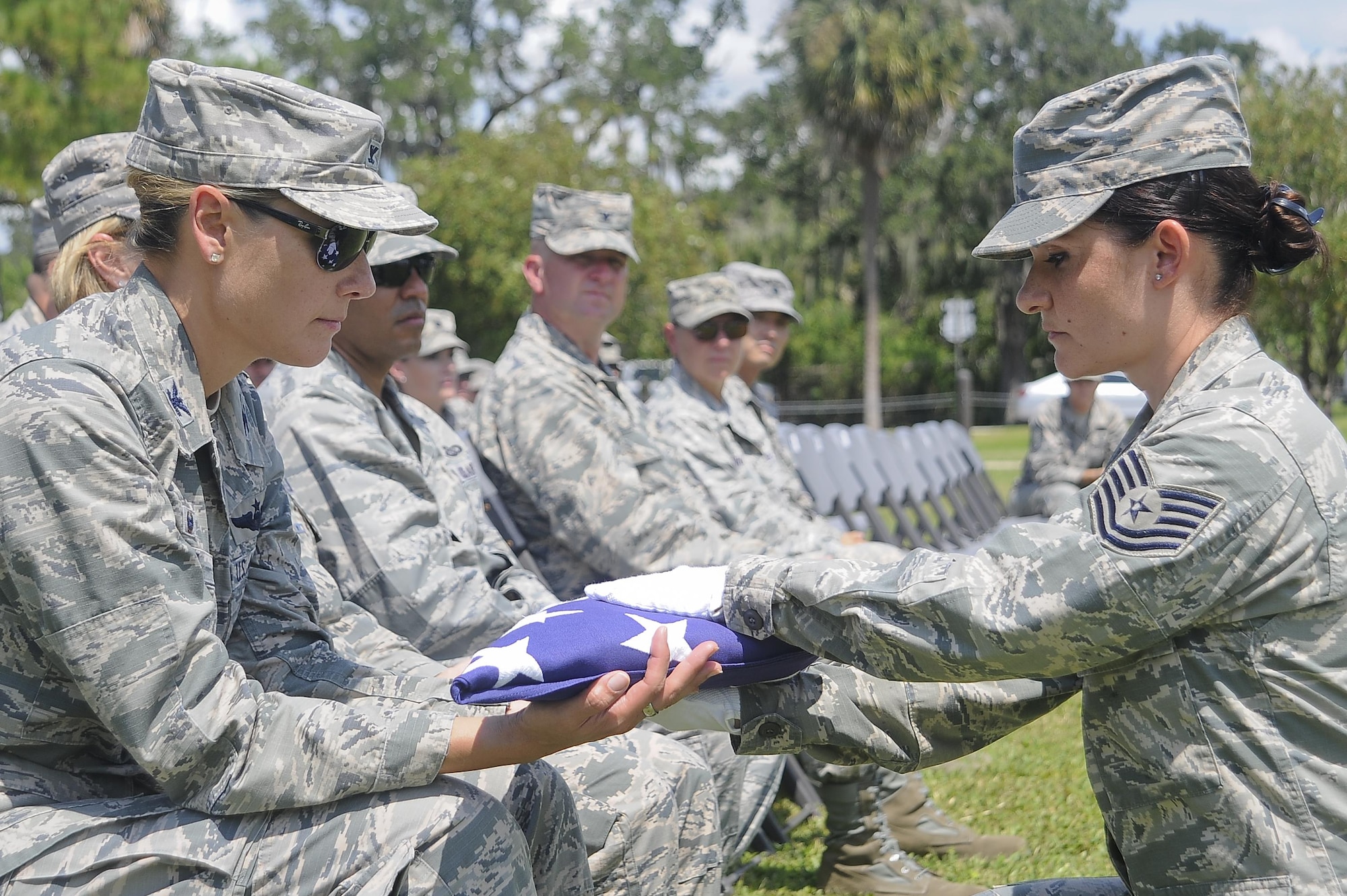 Col. April Vogel, left, the commander of the 6th Air Mobility Wing, is presented a flag from Tech. Sgt. Bajame Kirby, the NCO in charge of the MacDill Base Honor Guard assigned to the 6th Force Support Squadron, during an active-duty full-honors funeral demonstration at MacDill Air Force Base, Fla., Sept. 6, 2016. During a military funeral, the next of kin is presented the folded American flag. (U.S. Air Force photo by Airman 1st Class Mariette Adams)