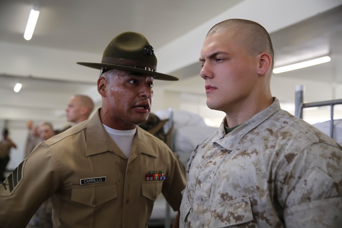Sergeant Nicholas A. Carrillo, drill instructor, Alpha Company, 1st Recruit Training Battalion, corrects a recruit during pick up at Marine Corps Recruit Depot San Diego, Sept. 9. In the first hours recruits are with their drill instructors they learn the rules and regulations of recruit training, covering everything from how to act in the squad bay to how to speak to the drill instructors. Annually, more than 17,000 males recruited from the Western Recruiting Region are trained at MCRD San Diego. Alpha Company is scheduled to graduate Dec. 2.