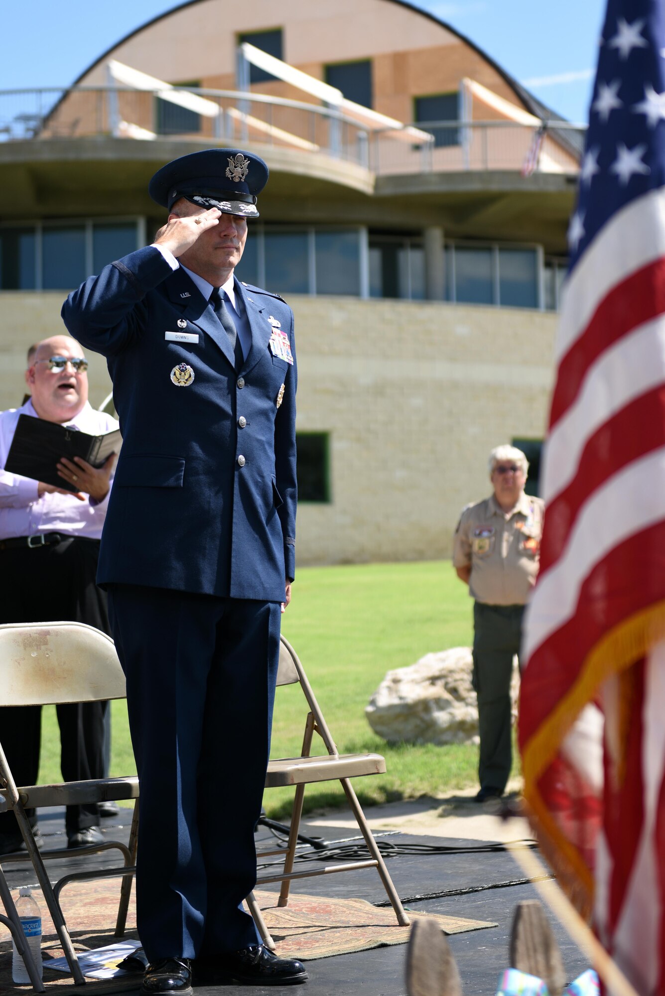U.S. Air Force Col. Michael Downs, 17th Training Wing Commander, salutes the American flag for the National Anthem during the San Angelo 9/11 Remembrance Ceremony at the Fine Arts Museum in San Angelo, Texas, Sept. 11, 2016. A local public school band and community choir performed the National Anthem for the ceremony. (U.S. Air Force photo by Airman 1st Class Caelynn Ferguson/Released)