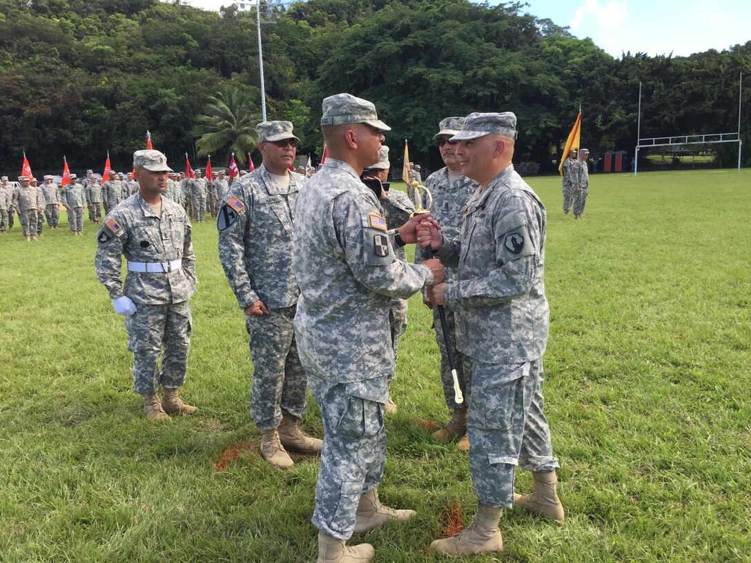 Brig. Gen. Alberto C. Rosende, 1st MSC Commanding General, presents the noncommissioned officer sword to Command Sgt. Maj. Orlando Santiago, charging him with the responsibility and authority of the 1st Mission Support Command  during the 1st MSC Change of Responsibility Ceremony, September 10 at the Maxi Williams Field on Fort Buchanan, Puerto Rico.