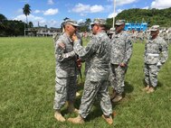 Command Sgt. Maj. Harry Muñoz relinquishes responsibility and authority of the 1st Mission Support Command to Command Sgt. Maj. Orlando Santiago during the 1st Mission Support Command Change of Responsibility Ceremony, September 10 at the Maxi Williams Field on Fort Buchanan, Puerto Rico.