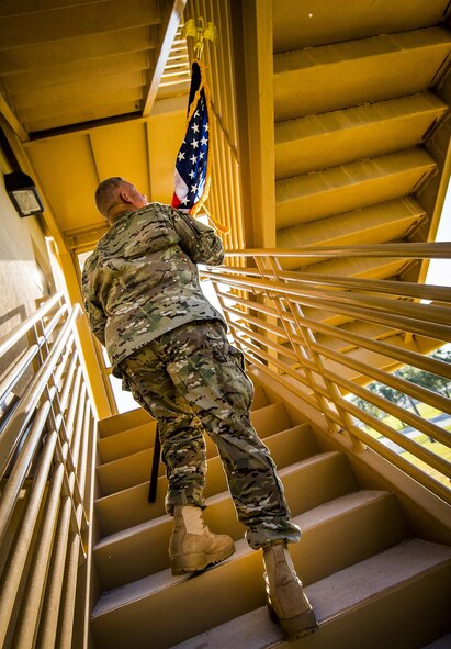 An Airman carries an American flag up a flight of stairs during a 9/11 Memorial Stair Climb event held at Duke Field, Fla., Sept. 10.  The 24-hour climb began at 8:46 a.m. with the 919th Special Operations Wing commander walking the flag up the outside stairwell of the base’s billeting facility.  Wing Airmen took turns walking the flag up and down the stairwell the entire day until it was delivered to a firefighter and security forces color guard at 8:46 a.m. the next morning for a 9/11 Remembrance ceremony. More than 115 Airmen carried the flag throughout the day and night for a total of more than 207,000 steps. (U.S. Air Force photo/Tech. Sgt. Sam King)