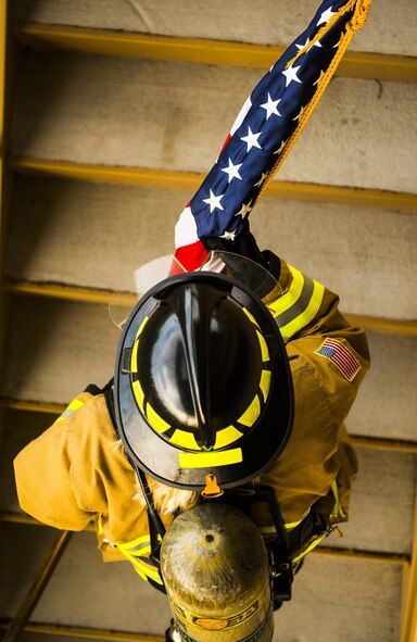 Senior Airman Raquelle Lockaby, 919th Special Operations Civil Engineer Squadron, carries an American flag up a flight of stairs while wearing her firefighter gear during a 9/11 Memorial Stair Climb event at Duke Field, Fla., Sept. 11.  The 24-hour climb began at 8:46 a.m. Sept. 10 with the 919th Special Operations Wing commander walking the flag up the outside stairwell of the base’s billeting facility.  Wing Airmen took turns walking the flag up and down the stairwell the entire day until it was delivered to a firefighter and security forces color guard at 8:46 a.m. the next morning for a 9/11 Remembrance ceremony. More than 115 Airmen carried the flag throughout the day and night for a total of more than 207,000 steps. (U.S. Air Force photo/Tech. Sgt. Sam King)