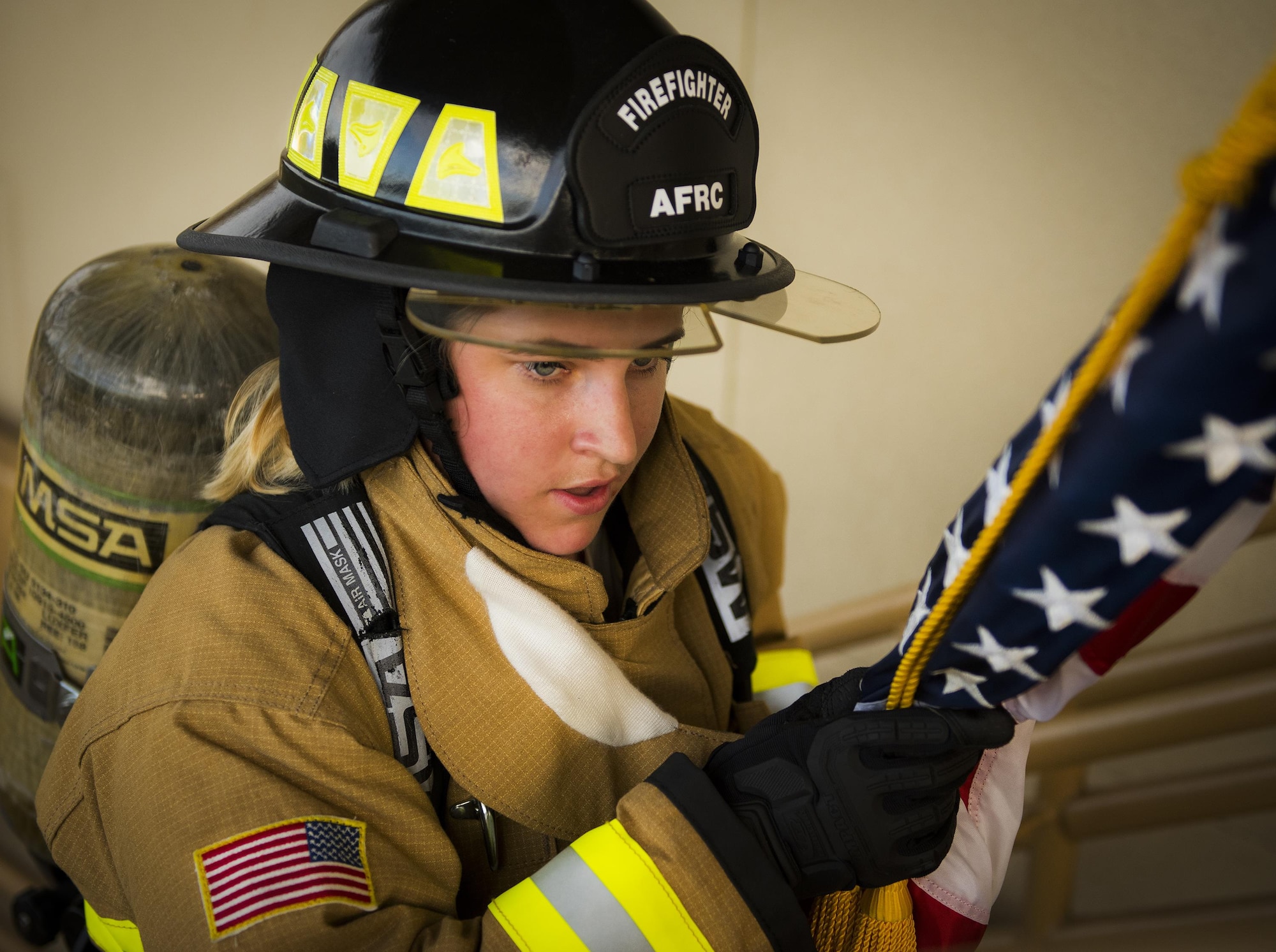 Senior Airman Raquelle Lockaby, 919th Special Operations Civil Engineer Squadron, carries an American flag up a flight of stairs while wearing her firefighter gear during a 9/11 Memorial Stair Climb event at Duke Field, Fla., Sept. 11.  The 24-hour climb began at 8:46 a.m. Sept. 10 with the 919th Special Operations Wing commander walking the flag up the outside stairwell of the base’s billeting facility.  Wing Airmen took turns walking the flag up and down the stairwell the entire day until it was delivered to a firefighter and security forces color guard at 8:46 a.m. the next morning for a 9/11 Remembrance ceremony.  More than 115 Airmen carried the flag throughout the day and night for a total of more than 207,000 steps.(U.S. Air Force photo/Tech. Sgt. Sam King)