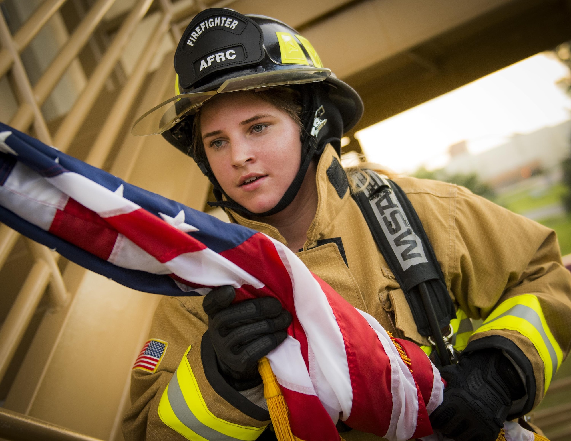 Senior Airman Raquelle Lockaby, 919th Special Operations Civil Engineer Squadron, carries an American flag up a flight of stairs while wearing her firefighting gear during a 9/11 Memorial Stair Climb event at Duke Field, Fla., Sept. 11.  The 24-hour climb began at 8:46 a.m. Sept. 10 with the 919th Special Operations Wing commander walking the flag up the outside stairwell of the base’s billeting facility.  Wing Airmen took turns walking the flag up and down the stairwell the entire day until it was delivered to a firefighter and security forces color guard at 8:46 a.m. the next morning for a 9/11 Remembrance ceremony. More than 115 Airmen carried the flag throughout the day and night for a total of more than 207,000 steps.  (U.S. Air Force photo/Tech. Sgt. Sam King)