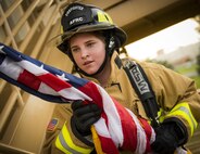 Senior Airman Raquelle Lockaby, 919th Special Operations Civil Engineer Squadron, carries an American flag up a flight of stairs while wearing her firefighting gear during a 9/11 Memorial Stair Climb event at Duke Field, Fla., Sept. 11.  The 24-hour climb began at 8:46 a.m. Sept. 10 with the 919th Special Operations Wing commander walking the flag up the outside stairwell of the base’s billeting facility.  Wing Airmen took turns walking the flag up and down the stairwell the entire day until it was delivered to a firefighter and security forces color guard at 8:46 a.m. the next morning for a 9/11 Remembrance ceremony. More than 115 Airmen carried the flag throughout the day and night for a total of more than 207,000 steps.  (U.S. Air Force photo/Tech. Sgt. Sam King)