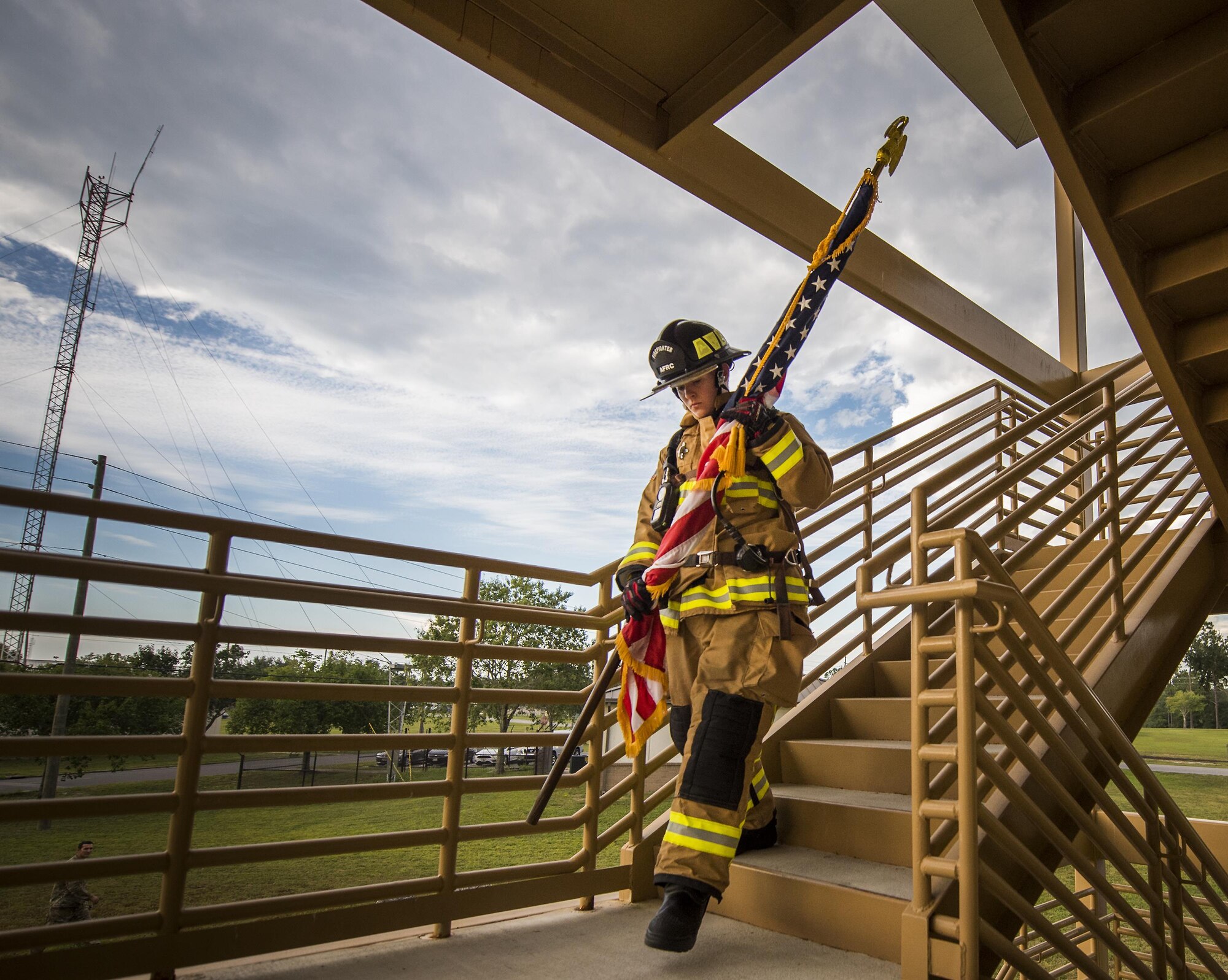 Airman Virginia Davis, 919th Special Operations Civil Engineer Squadron, carries an American flag down a flight of stairs while wearing her firefighter gear during a 9/11 Memorial Stair Climb event at Duke Field, Fla., Sept. 11.  The 24-hour climb began at 8:46 a.m. Sept. 10 with the 919th Special Operations Wing commander walking the flag up the outside stairwell of the base’s billeting facility.  Wing Airmen took turns walking the flag up and down the stairwell the entire day until it was delivered to a firefighter and security forces color guard at 8:46 a.m. the next morning for a 9/11 Remembrance ceremony.  More than 115 Airmen carried the flag throughout the day and night for a total of more than 207,000 steps.  (U.S. Air Force photo/Tech. Sgt. Sam King)