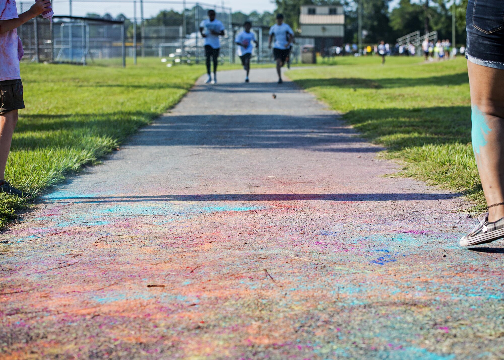 The last wave of runners race towards a ‘splash zone’ during a Kid’s Color Run, Sept. 10, 2016, at Moody Air Force Base, Ga. The event was free and each participant was given a white t-shirt with hopes that it would be colored with chalk by the end of their run. (U.S. Air Force photo by Airman 1st Class Janiqua P. Robinson)