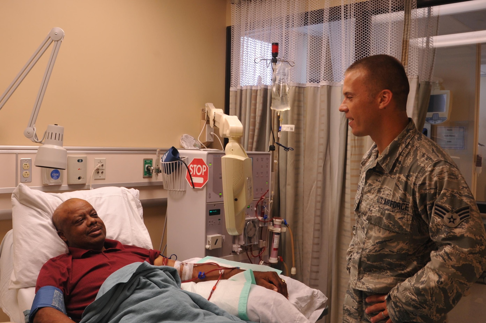 Dialysis Technician Senior Airman Jason Scoles checks on his patient, John Pennix, as he is receiving his dialysis treatment at the Wright-Patterson Medical Center on August 26, 2016. (U.S. Air Force photo/Stacey Geiger)