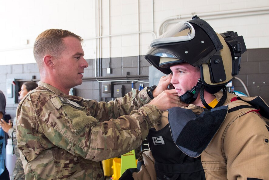 U.S. Air Force Senior Airman Clayton Smith, 23d Civil Engineer Squadron explosive ordinance disposal specialist, fits an EOD-9 bomb suit on Matthew Dubois, Camden County High School student, Sept. 9, 2016, at Moody Air Force Base, Ga. Smith was one of approximately 50 Airmen who assisted the attendees by answering questions and demonstrating various mission capabilities. (U.S. Air Force photo by Airman 1st Class Greg Nash)
